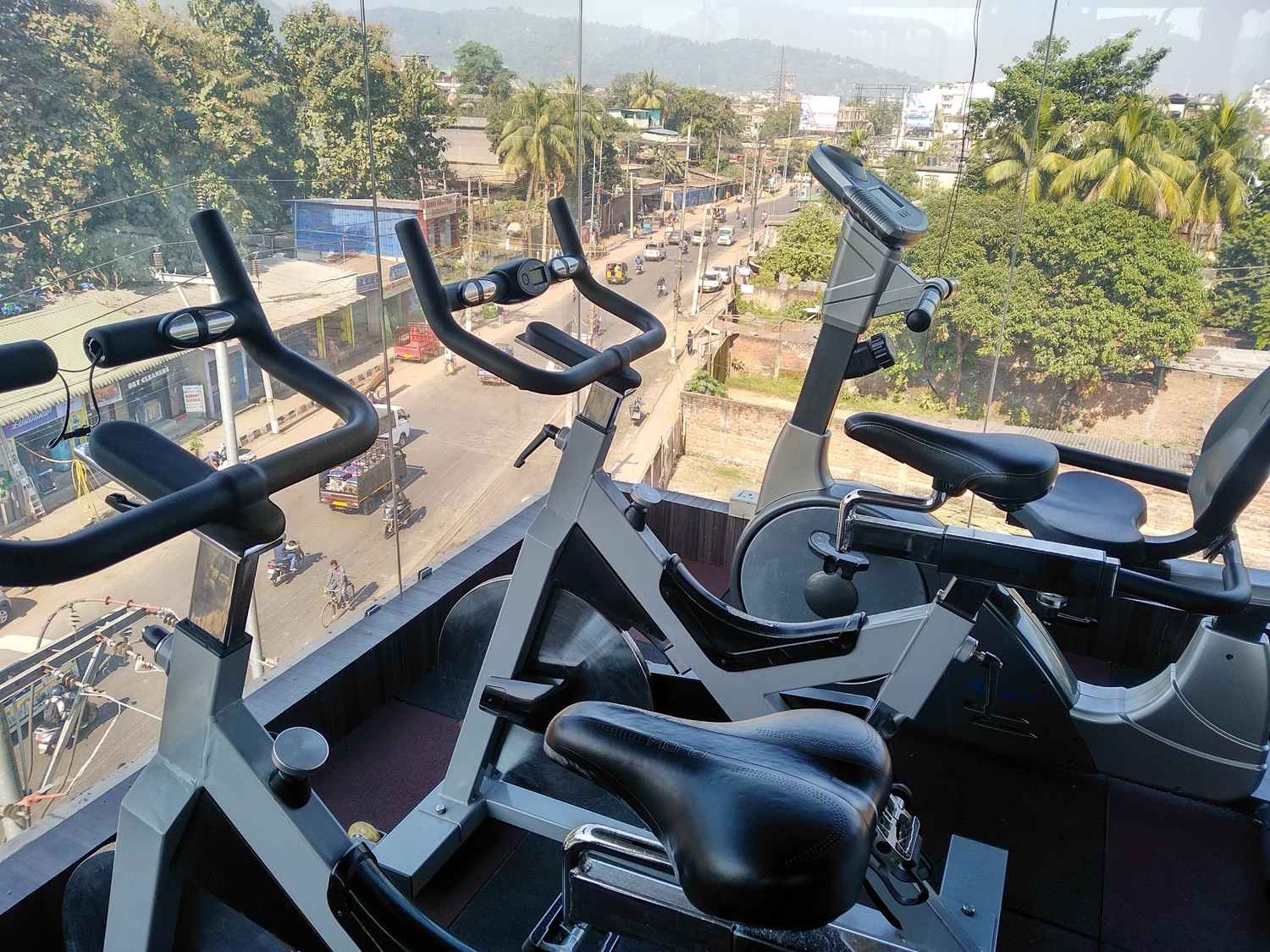 Spin bikes at the window, looking down over Lal Ganesh main road