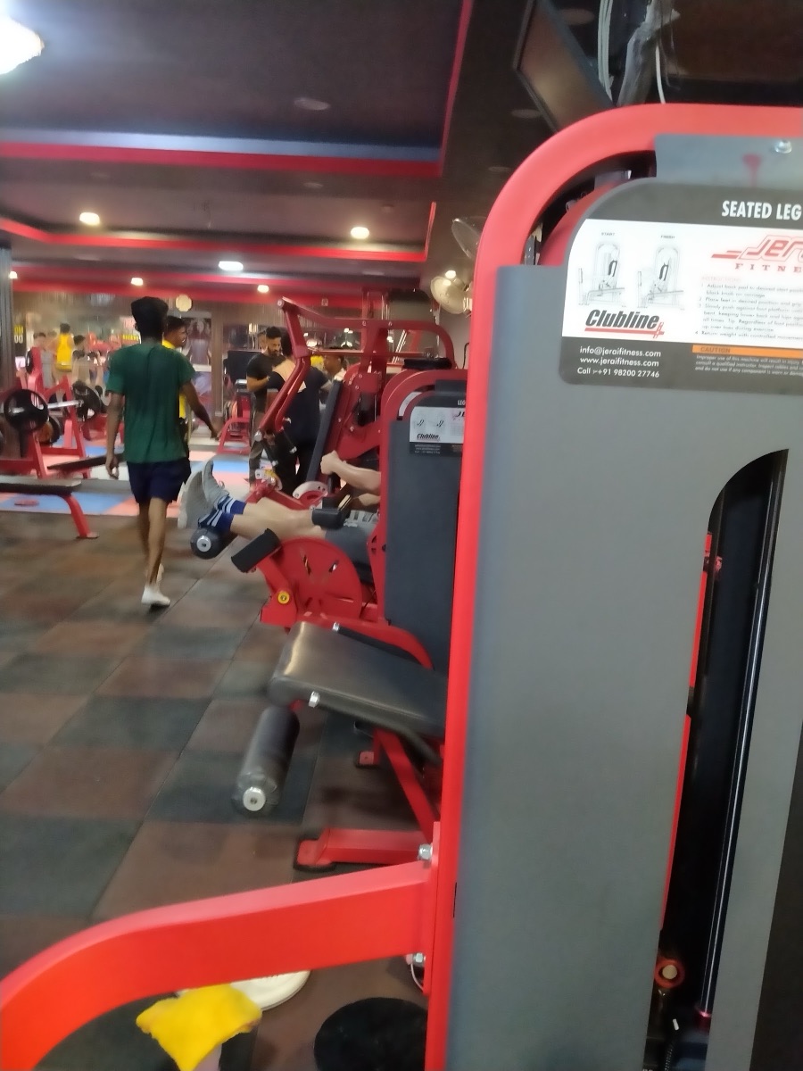 Red and grey weight machines with a member walking past