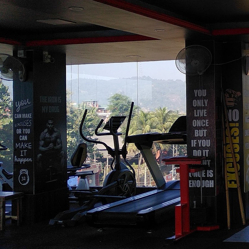 Pillars painted with lines such as You can make excuses or you can make it happen, beside the cardio machines